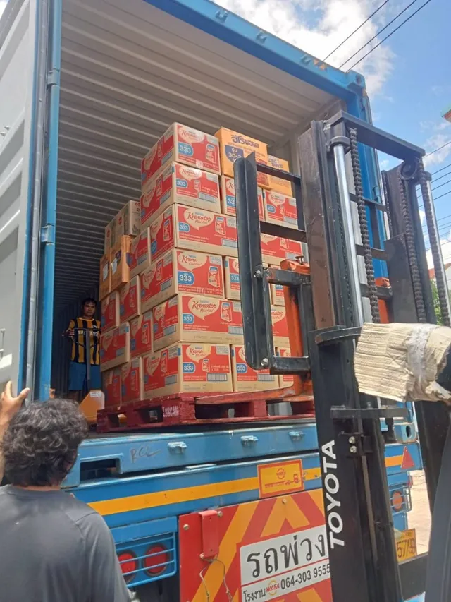 A forklift lifts a pallet of creamer cartons into a 40 ft container at the Bangkok warehouse.
