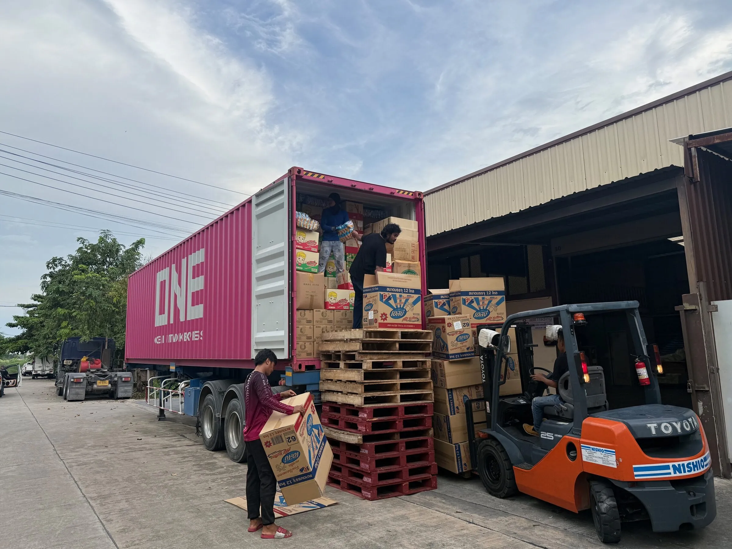 aBit Trading staff loading mixed cartons of Thai consumer goods into a container at the company's Bangkok warehouse